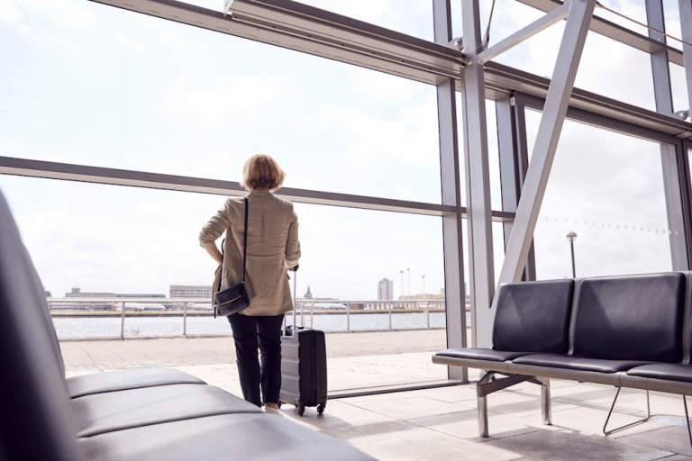 woman looking out airport window leaving & starting over