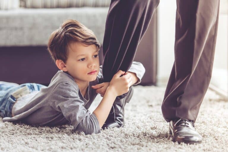 child holding fathers leg not letting go