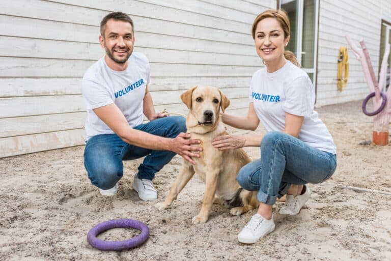 man woman volunteering at humane center with dog