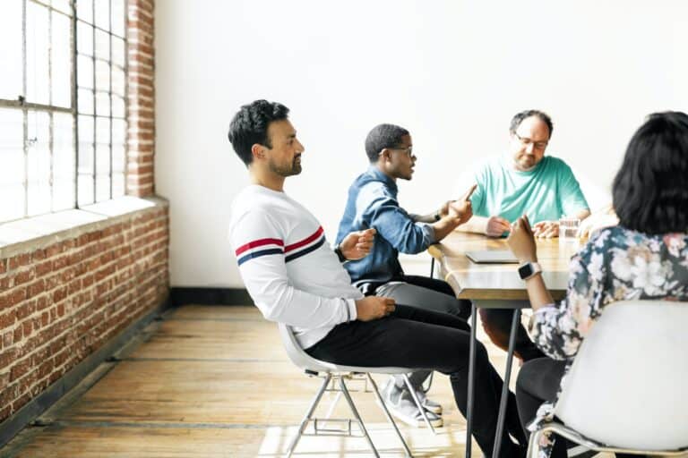 Individual sitting back in chair during a meeting with with quiet confidence